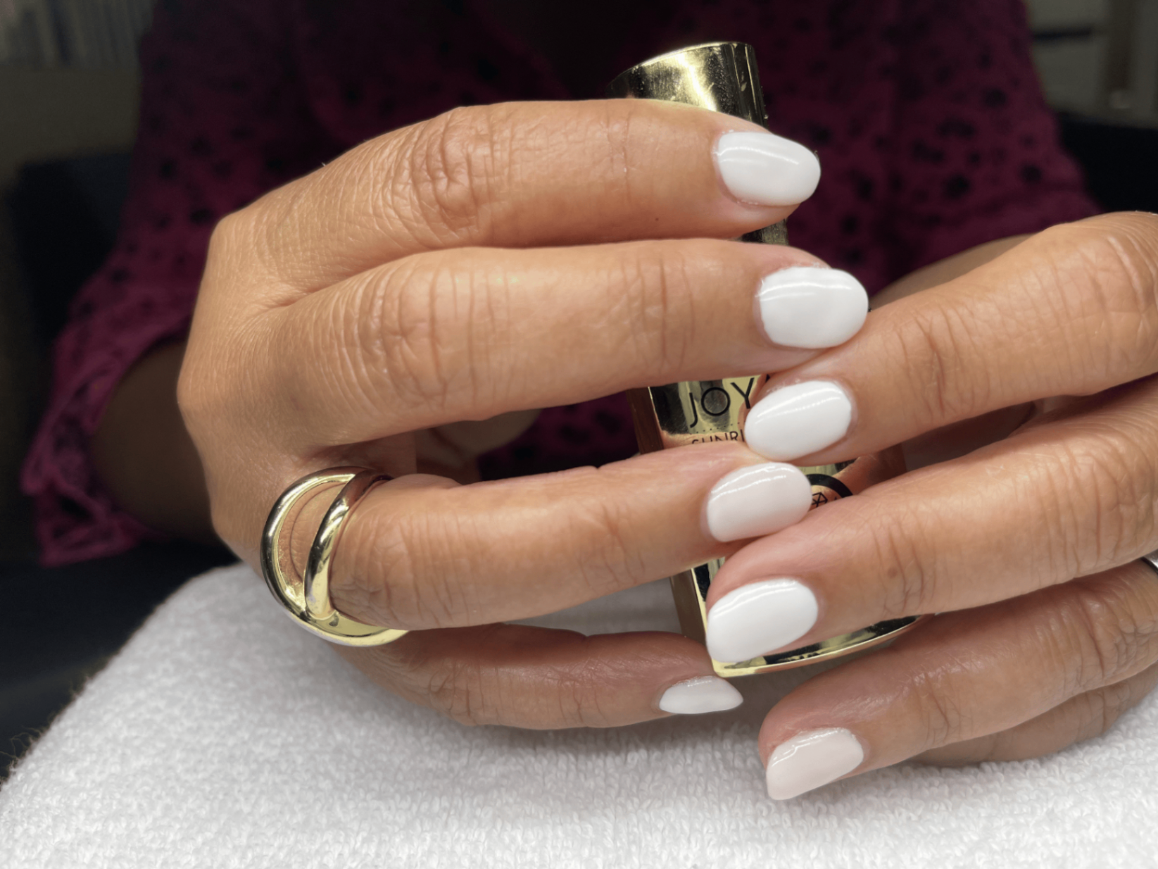 Glossy white manicure with gold accessories